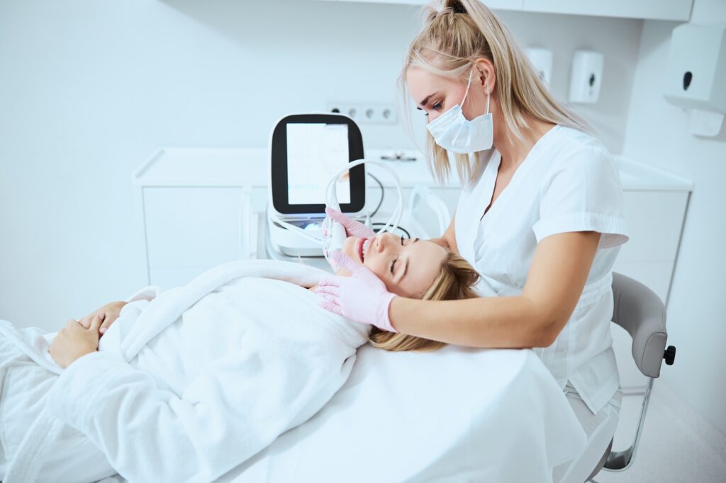 Pleased young patient receiving the microneedling treatment